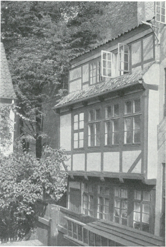 Overgaden neden Vandet 31 med plankeværk, der i 1930'erne blev afløst af en 24 meter høj mur (Torvegade-bebyggelsen). Foto fra 1913, mens karréen havde små haver og skønne steder med lys og luft